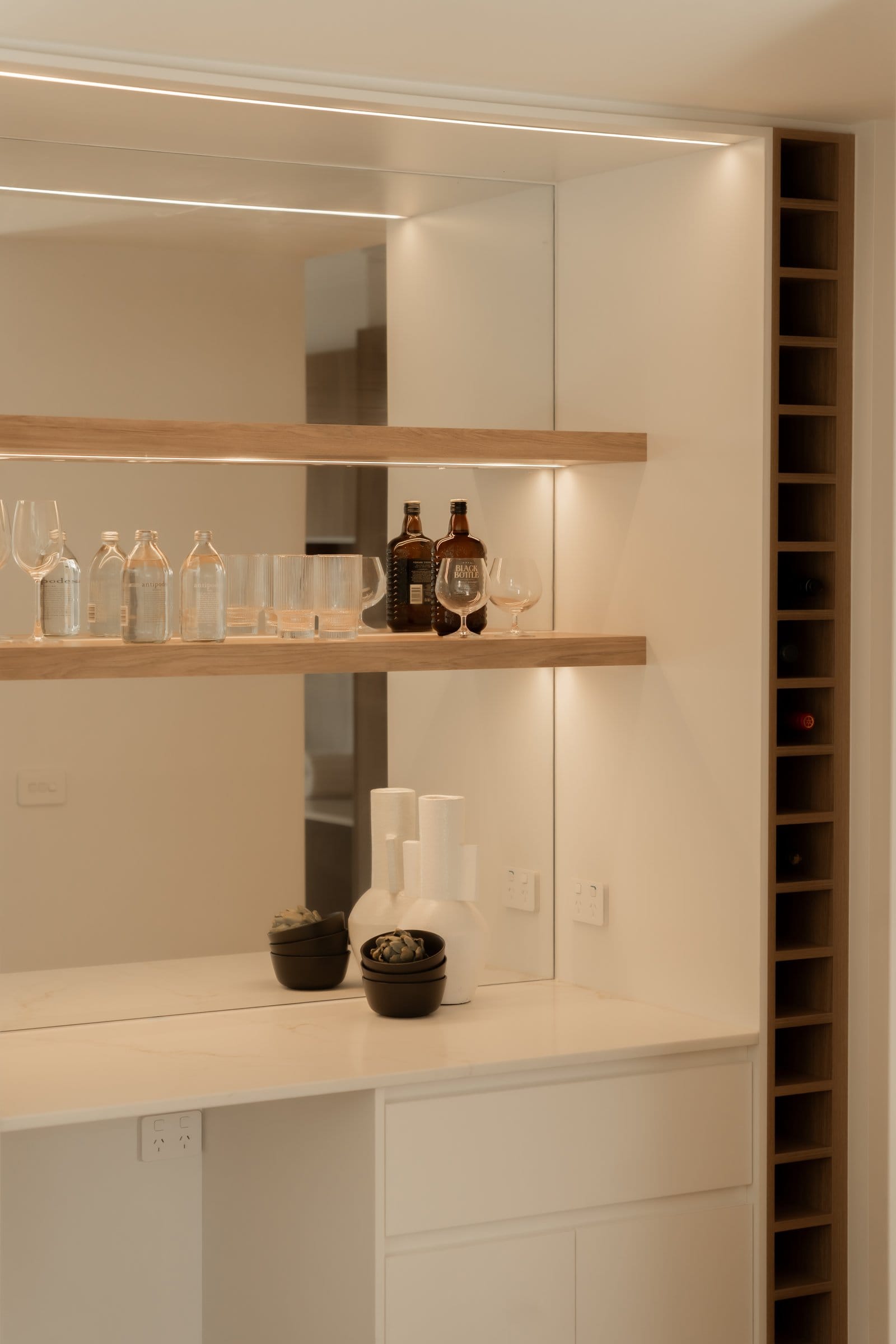 Kitchen with a stone benchtop and black tapware opening to the rear garden