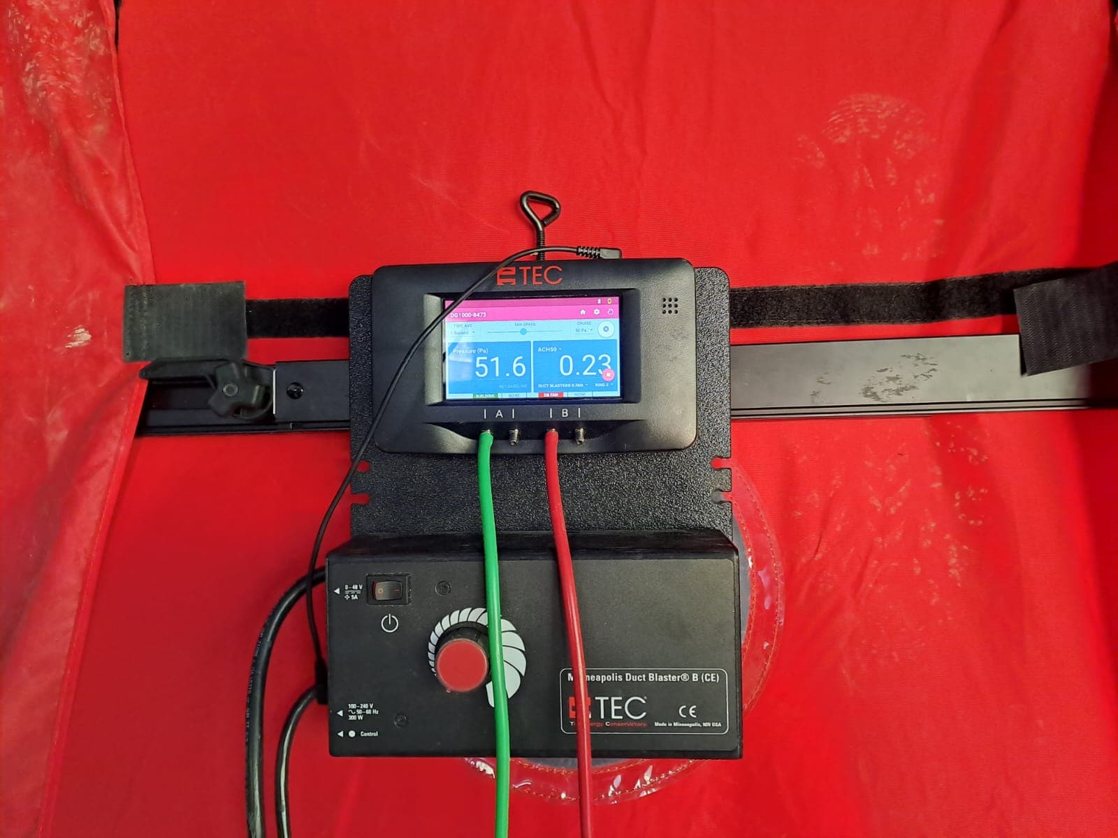 Digital gauge showing a live pressure and airtightness reading during a blower-door test