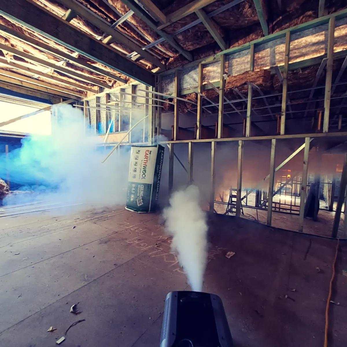 Smoke machine testing for air leaks inside a Marvel Homes passive house frame, with insulation visible