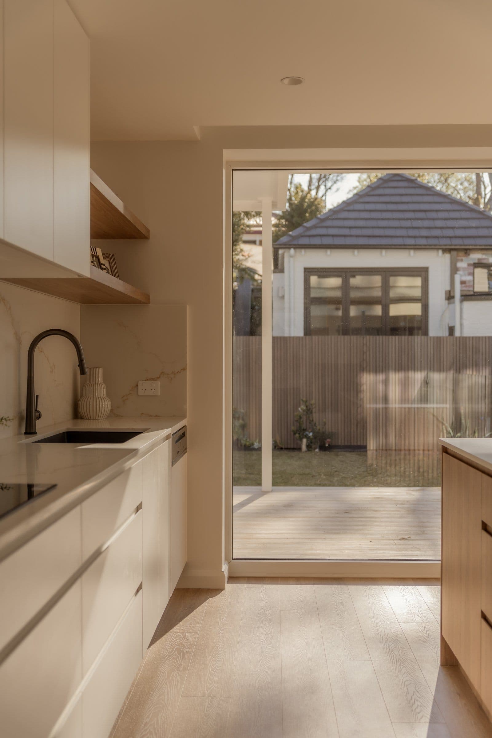 Lilyfield kitchen opening to the garden through a full-height sliding door
