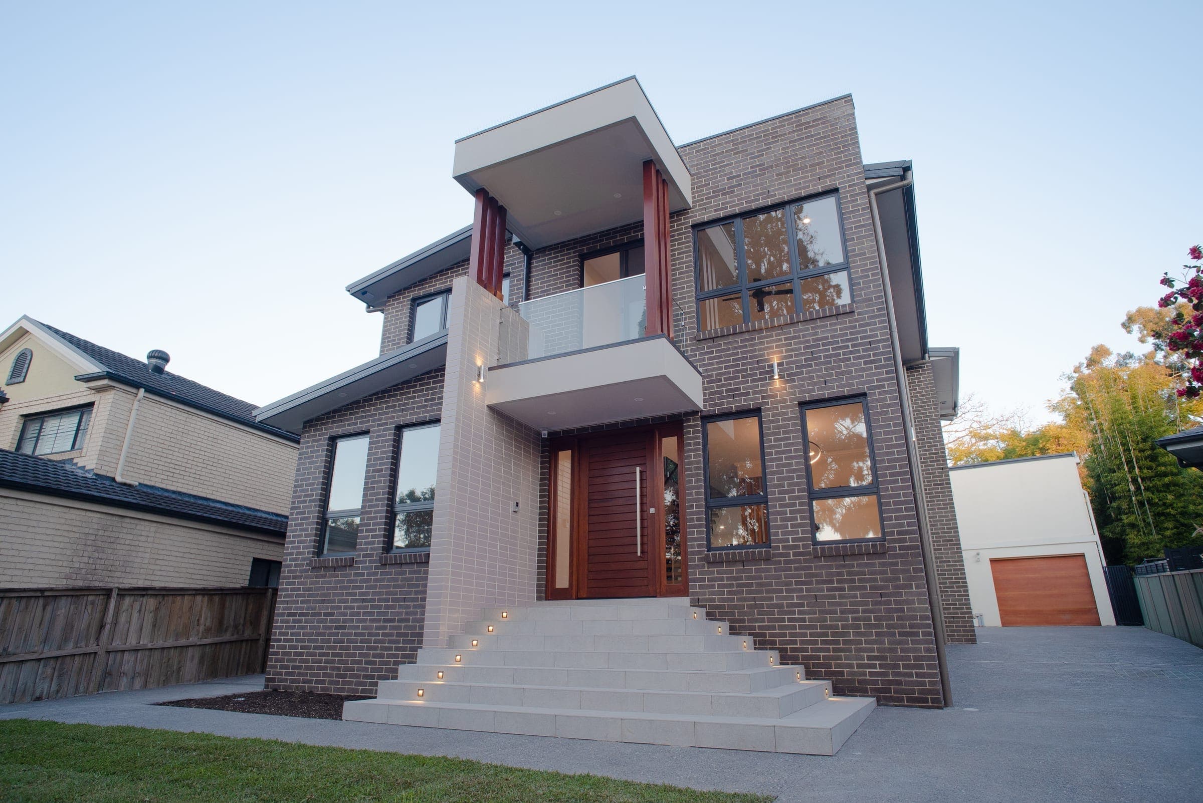 Ryde custom home, a brick and render two-storey facade lit at dusk