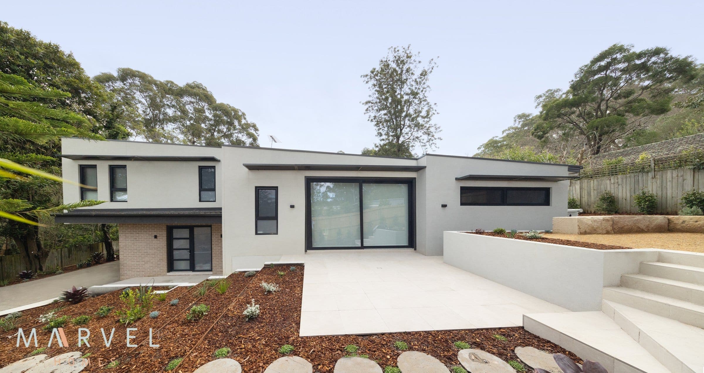 Warrawee passive house, a clean white two-storey facade set into a leafy Upper North Shore garden