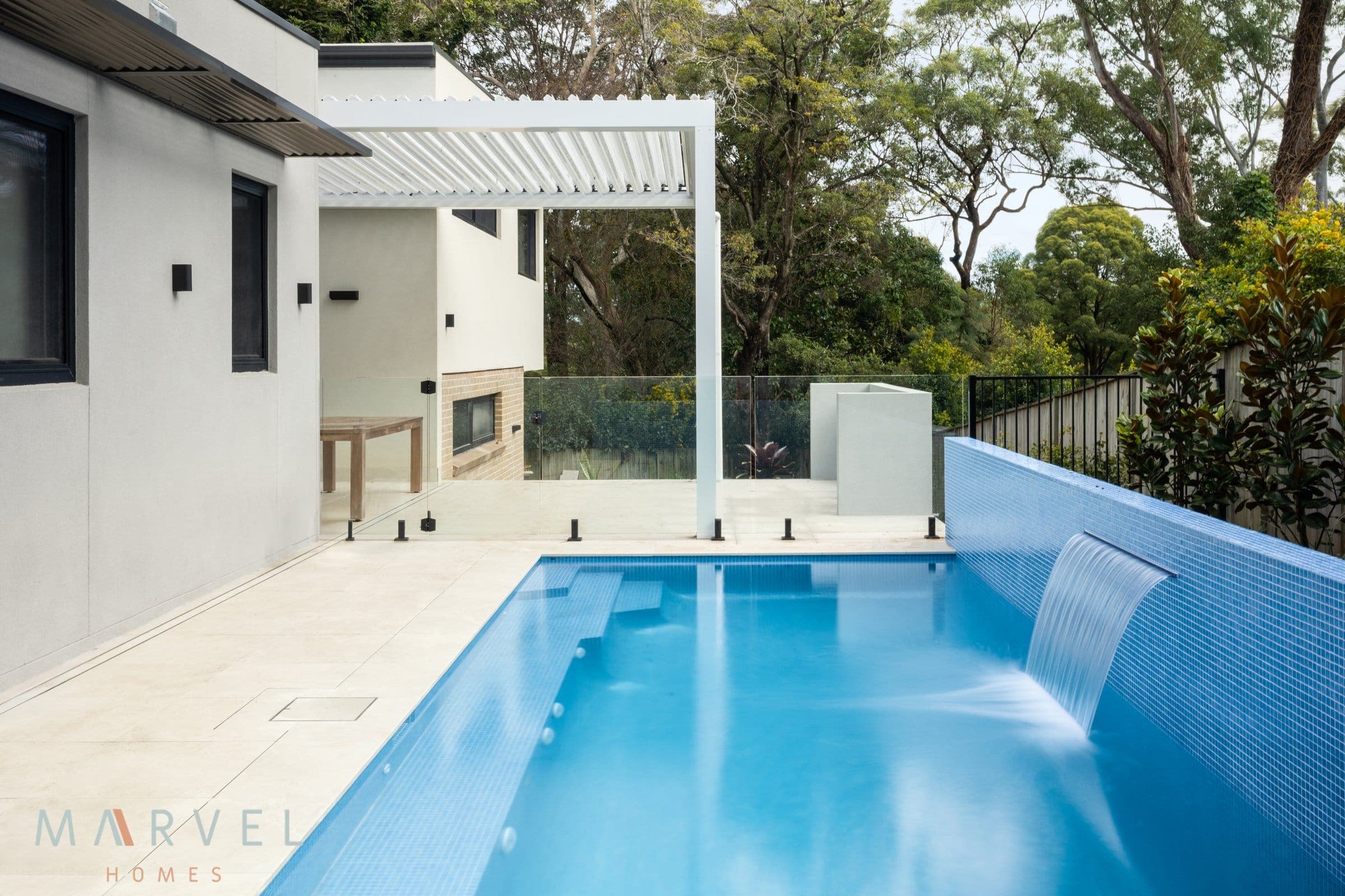 Finished Marvel Homes pool terrace at Warrawee with water feature and bush outlook