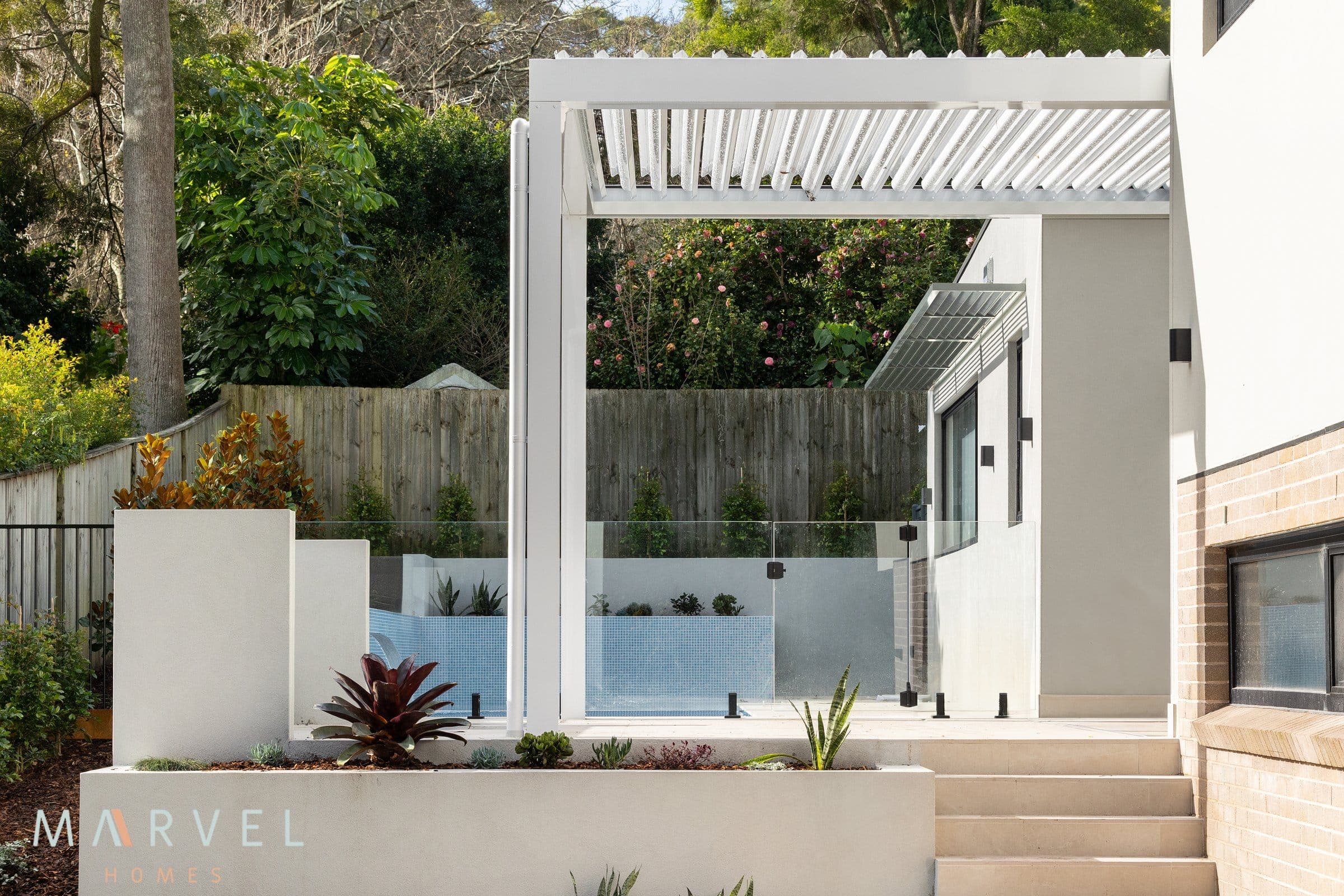Warrawee passive house alfresco and pool area beneath a white louvered pergola