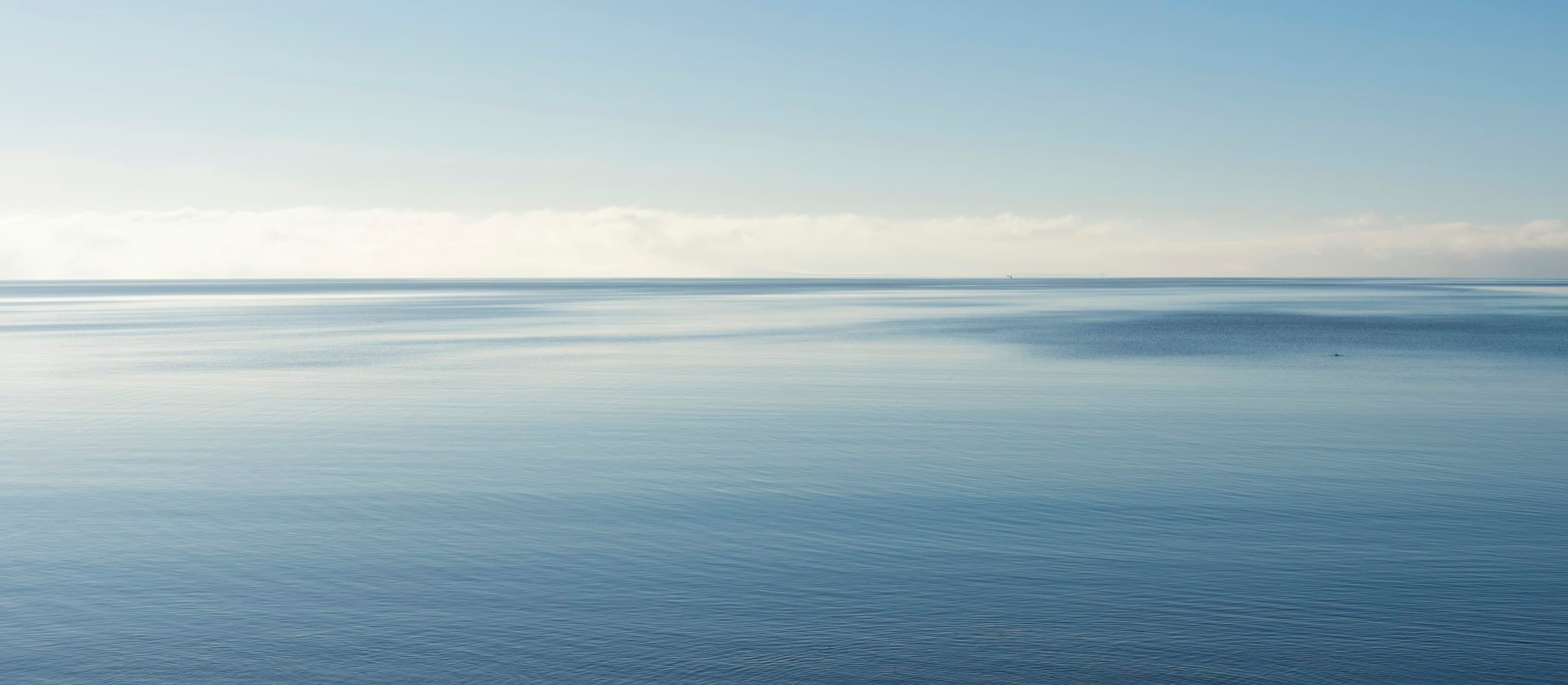 A calm ocean horizon under a clear sky